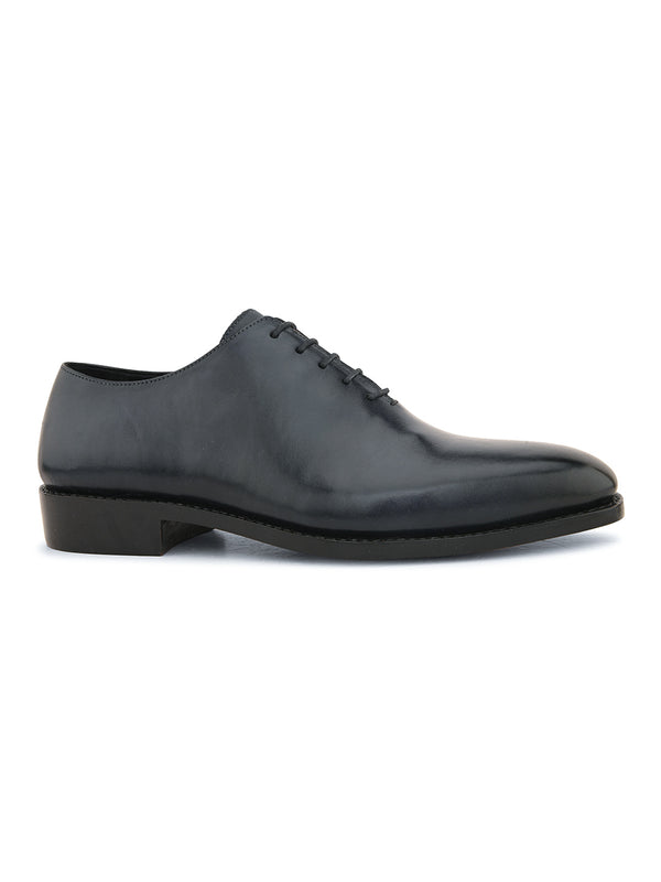 Men’s black wholecut leather Oxford shoes showcasing clean silhouette, smooth finish and lace-up style