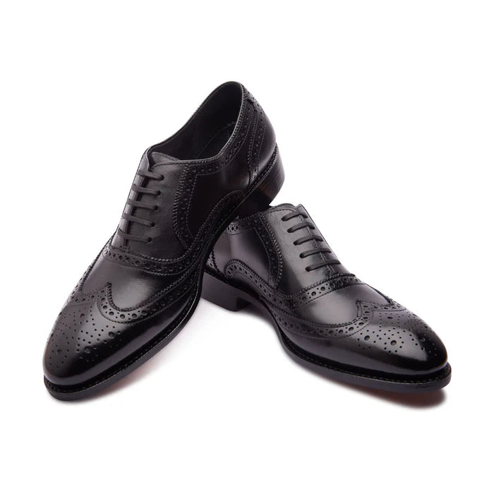 Close-up of brogue detailing on black Oxford shoes
