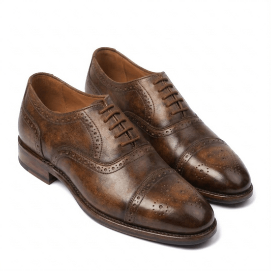 A pair of premium brown leather semi-brogue Oxford shoes featuring a unique mottled patina finish, intricate decorative perforations, and matching brown laces on a white background.