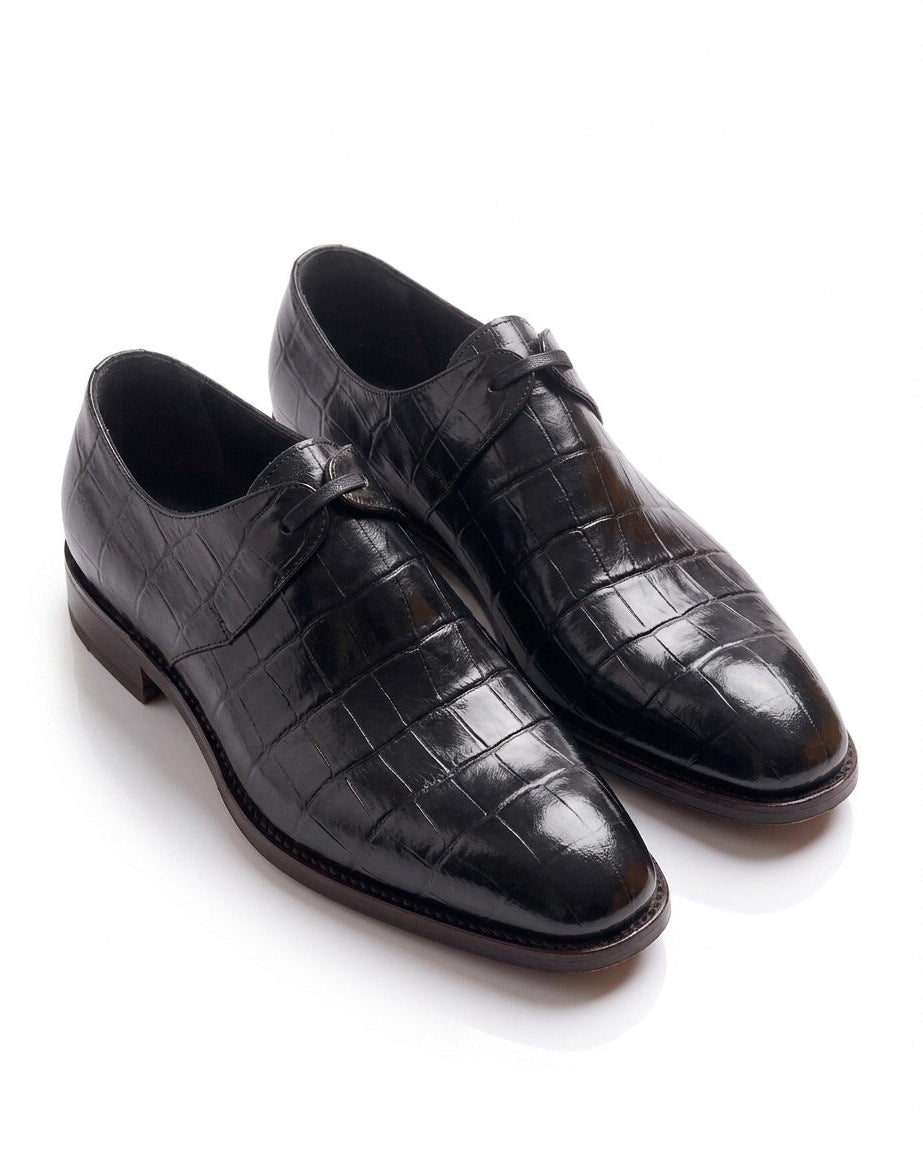 Pair of luxury black crocodile-embossed leather derby dress shoes with a high-shine finish.
