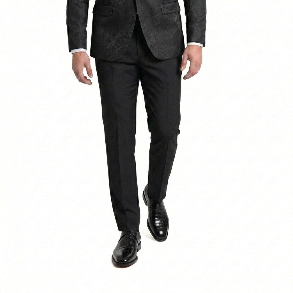 Man walking in a black floral jacquard blazer and tailored trousers paired with black crocodile-embossed leather shoes.