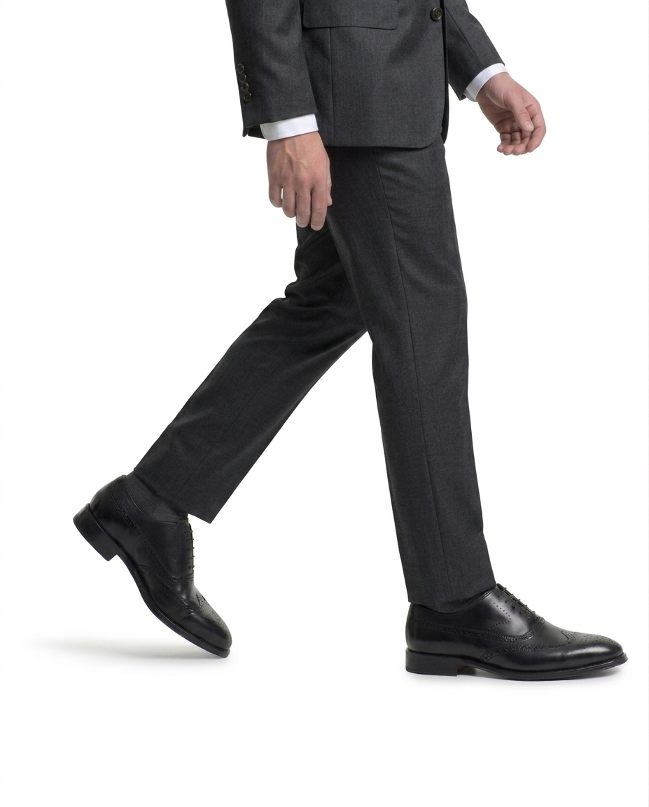 Side view of man walking in grey suit wearing black leather oxford dress shoes