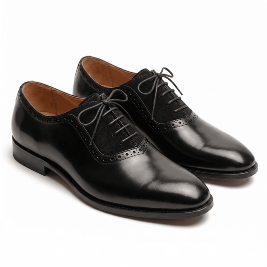 A pair of luxury black leather Oxford shoes featuring a unique suede mid-panel and classic brogue detailing.