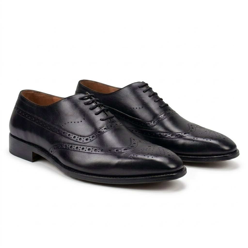 Pair of premium black leather wingtip brogue Oxford shoes for men, featuring intricate decorative perforations and a polished finish on a white background.