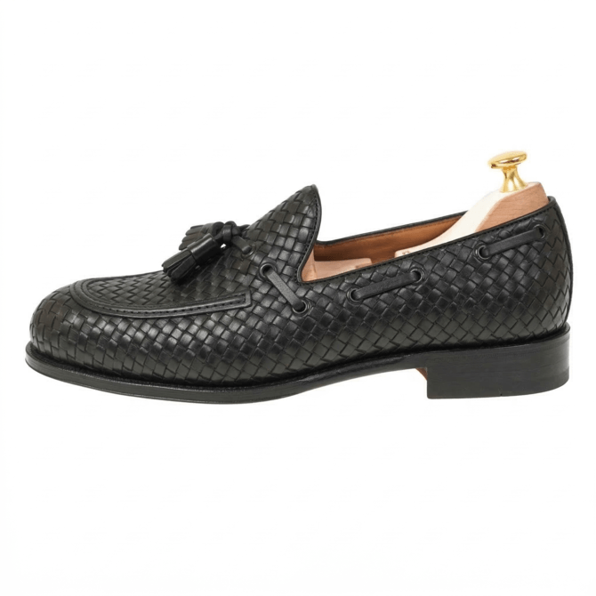 Side profile of handcrafted black woven leather tassel loafers with formal dress shoe styling