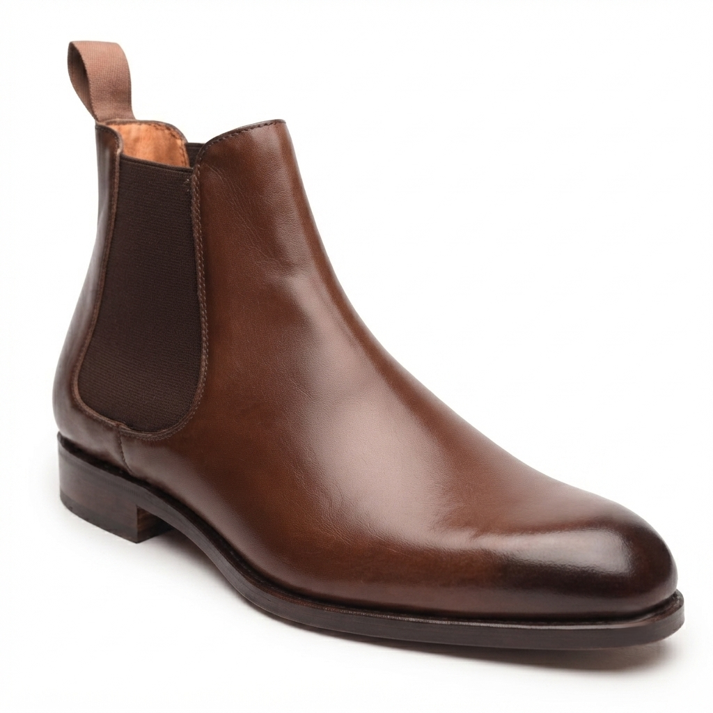 Side profile of brown leather Chelsea boots for men featuring elastic side panels, pull tabs, and a refined silhouette.