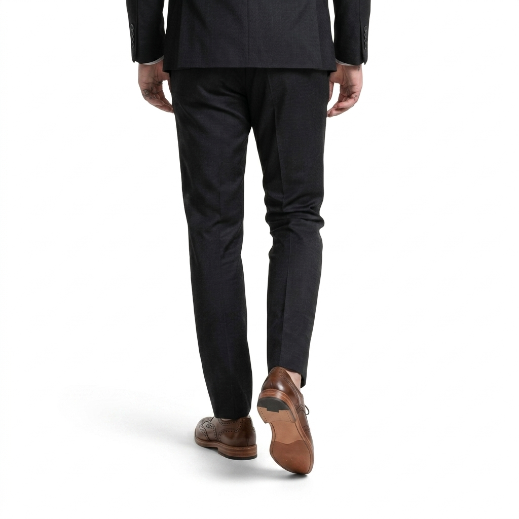 Back view of man wearing black formal suit with cognac brown brogue derby leather shoes walking