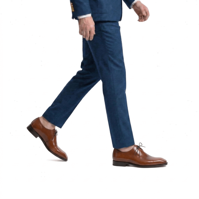 Side walking view of men wearing brown patina derby shoes