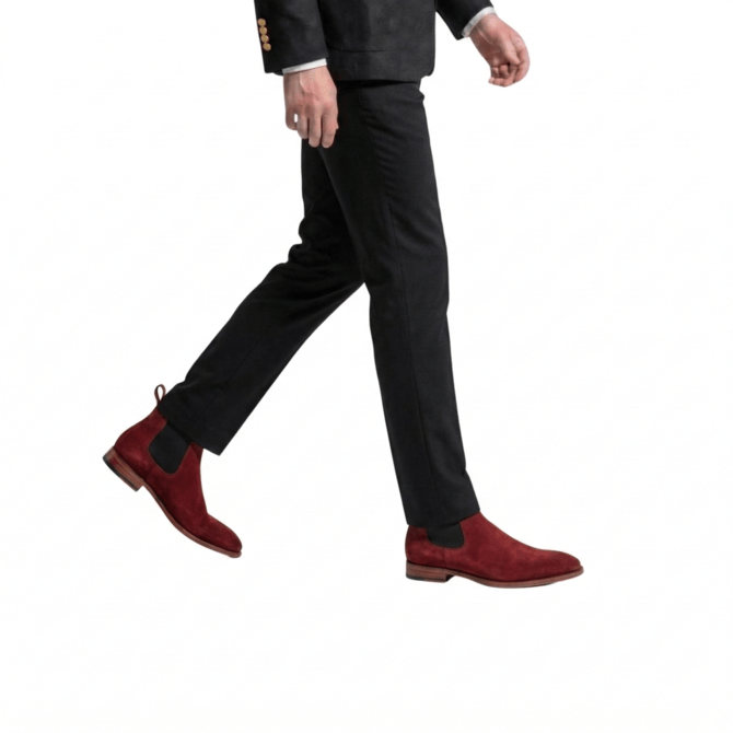 Profile walking view of luxury burgundy suede Chelsea boots for men, featuring black elastic side panels and durable leather soles.