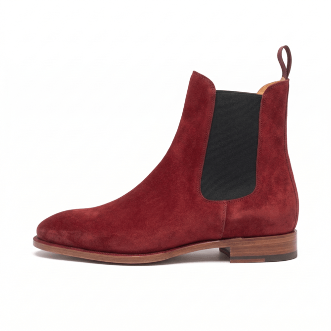 Lateral side profile of a luxury men's Chelsea boot in deep burgundy suede, featuring a clean leather sole, black elastic side panel, and a single matching pull tab.