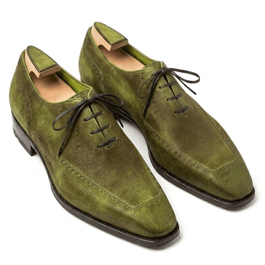 A pair of luxury olive green wholecut Oxford shoes featuring a hand-burnished patina finish and a sleek chiselled toe.