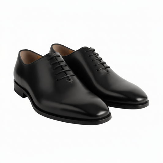 Three-quarter view of luxury black leather wholecut Oxford shoes for men.
