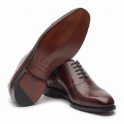 Bottom view of burgundy brown leather Oxford shoes showing the sole design