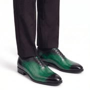Green leather dress shoes worn with formal trousers