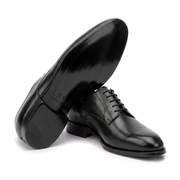 Angled view of black leather Oxford shoes showing leather soles