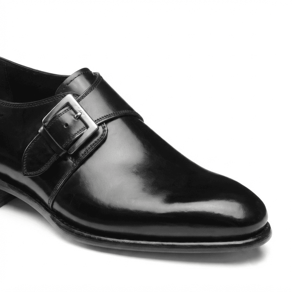 Close-up side view of black patent leather monk strap shoe