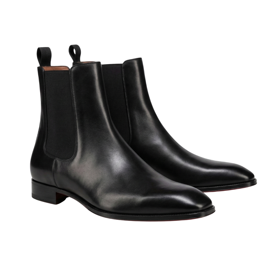 A pair of sleek, premium black leather Chelsea boots for men, featuring a polished finish, elastic side panels, and pull tabs at the heel, showcased against a clean white background.