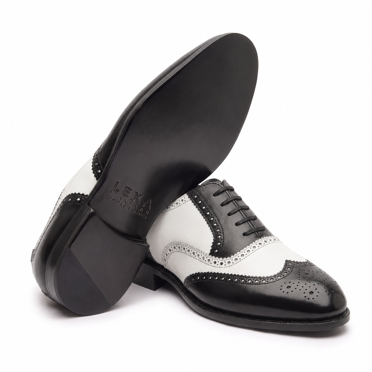 Angled view of black and white leather brogue shoes showing soles