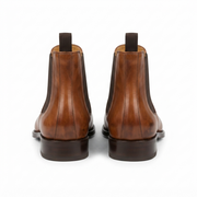 Rear view of brown leather Chelsea boots highlighting heel detail and pull tabs.