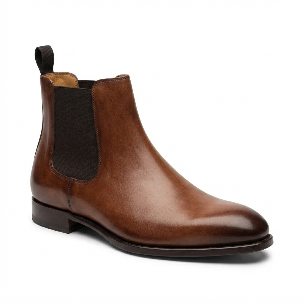 Profile view of a single brown leather Chelsea boot pointing right.