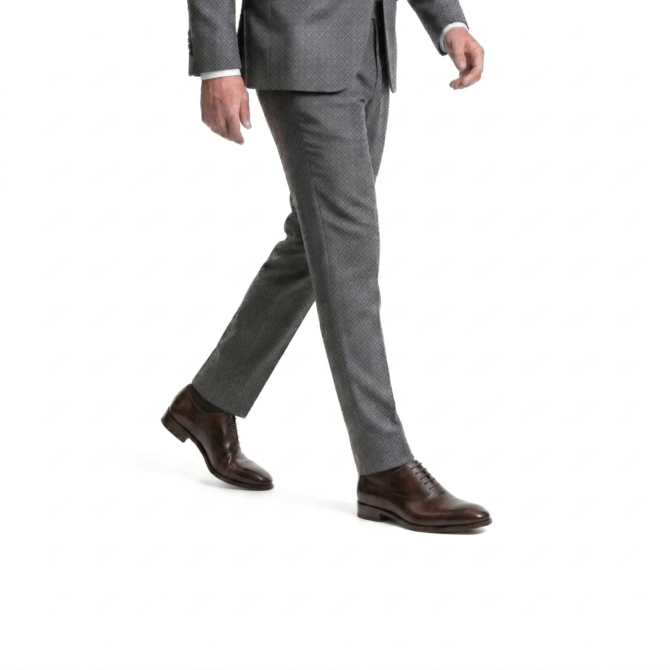 Side view of a man walking in a grey diamond-patterned suit with slim-fit trousers and premium dark brown leather oxford dress shoes.