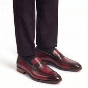 Burgundy leather penny loafers for men worn with formal trousers