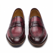 Front view of a pair of burgundy leather penny loafers for men