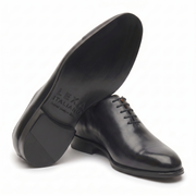 Bottom view of black leather Oxford shoes showing leather sole