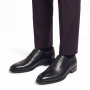 Black leather Oxford shoes worn with formal trousers