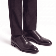 Dark brown leather dress shoes worn with formal trousers
