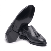 Angled top view of black leather horsebit loafers for men