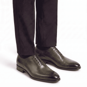Olive green leather Oxford shoes worn with formal trousers