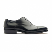 Black leather Oxford shoes showing the outsole and heel design