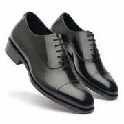Pair of black leather Oxford shoes shown from a three-quarter angle