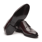 Angled view of dark brown leather Oxford shoes showing the soles