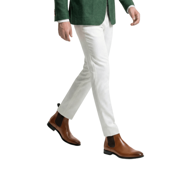 Brown leather Chelsea boots with light trousers men's walking side view