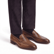 Brown leather loafers for men worn with dark trousers