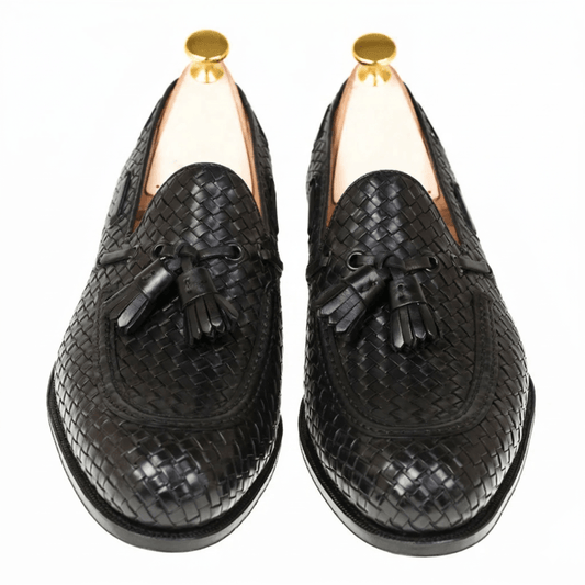 Top angle view of premium black woven leather loafers with elegant tassel detailing