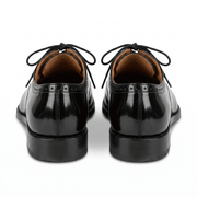 Back view of the shoes highlighting the polished leather heel counters and clean stitching.