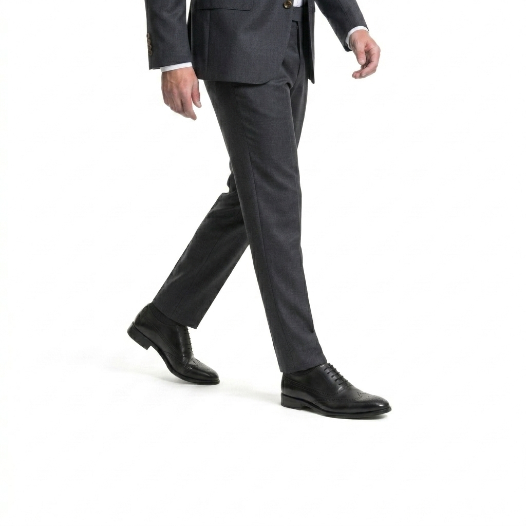 Man walking in grey suit wearing premium black leather oxford dress shoes on white background