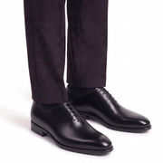 Men's black leather Oxford shoes paired with formal trousers for a timeless business and formal look.