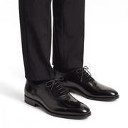The black leather and suede Oxfords styled with black tailored trousers for a professional formal look.