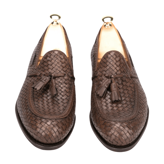 Top angle view of luxury brown woven leather loafers with elegant tassel detailing
