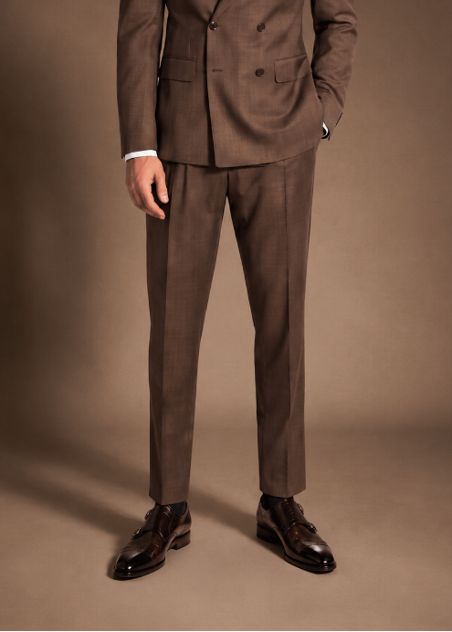 Man wearing a brown double-breasted suit with dark brown leather monk strap shoes in a studio setting.