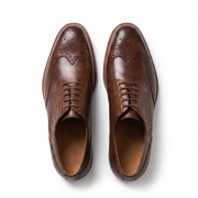 Top view of brown leather wingtip oxford shoes for men with brogue detailing formal footwear