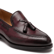 Close-up front view of burgundy leather tassel loafer showing tassel detailing