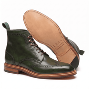 Side view of the green boot with the tan leather sole exposed to show the craftsmanship and branding.