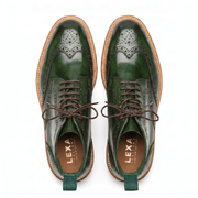Overhead view of green leather dress boots showing the intricate wingtip perforations and matching green pull tabs.