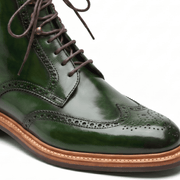 Macro close-up focusing on the forest green leather texture, broguing details, and fine stitching.