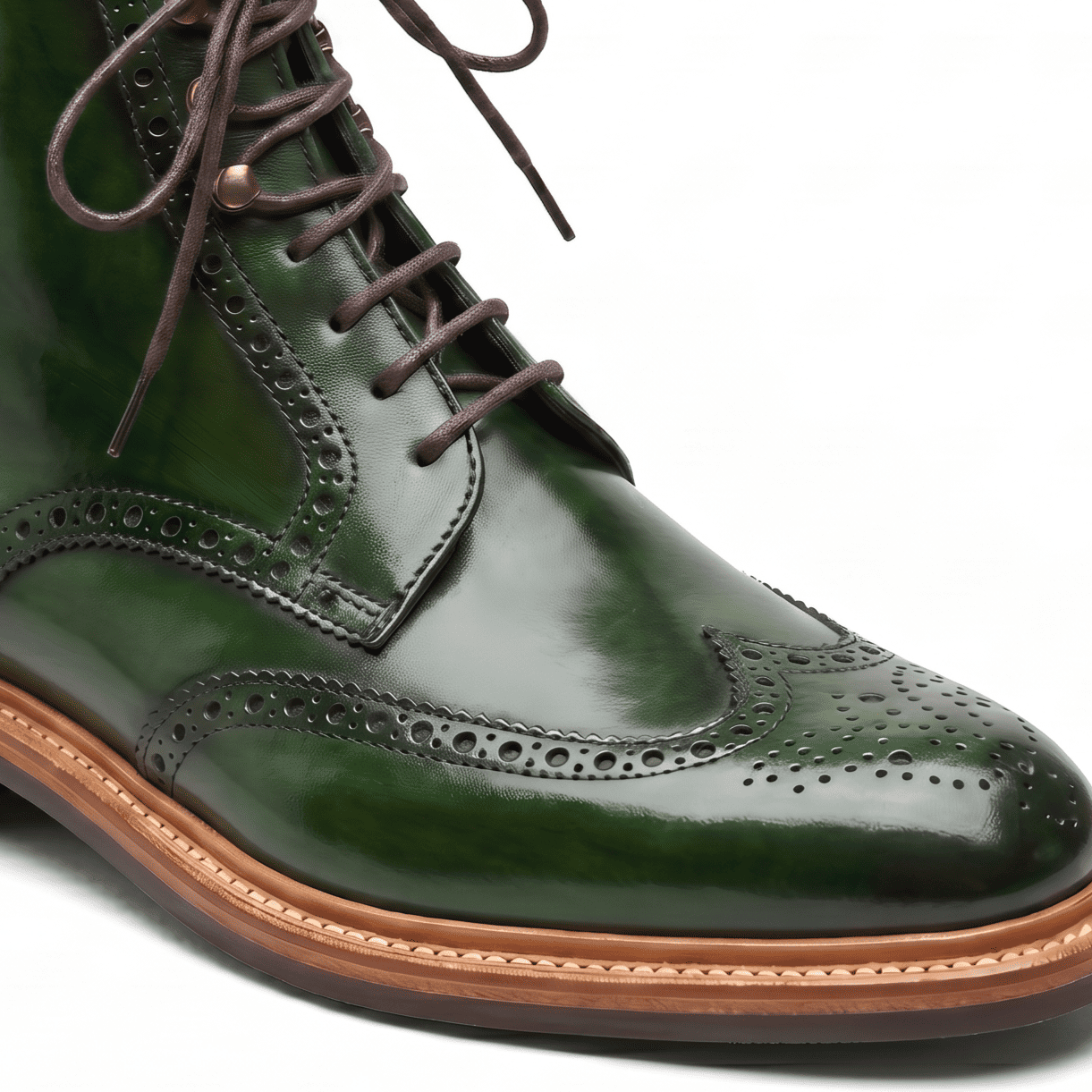 Macro close-up focusing on the forest green leather texture, broguing details, and fine stitching.